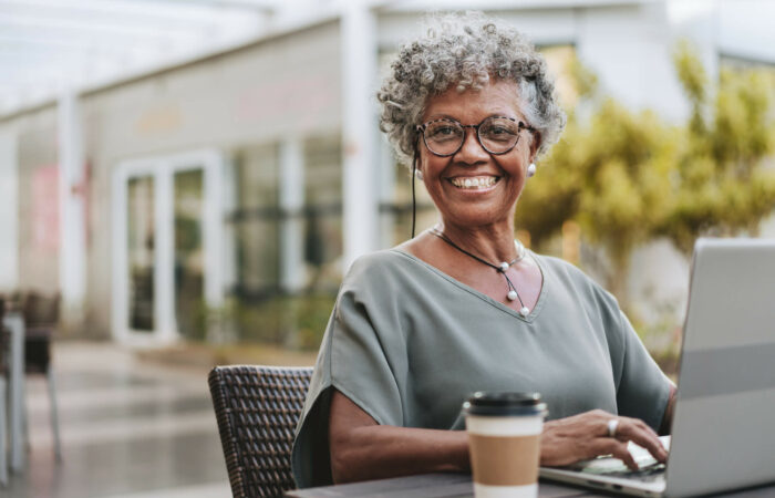 Femme souriante d'age mur sur son ordinateur